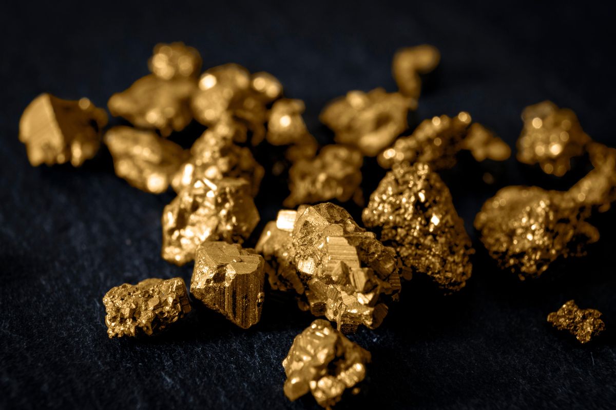 Gold nuggets on black surface.