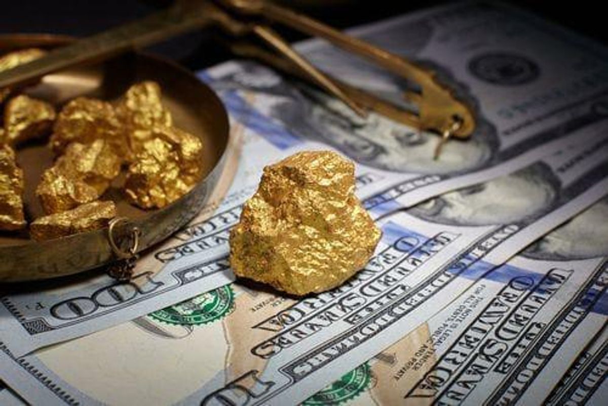 gold pieces on top of US$100 bills