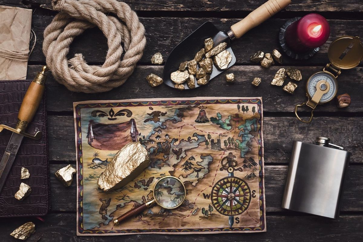Gold surrounded by exploration tools and maps.