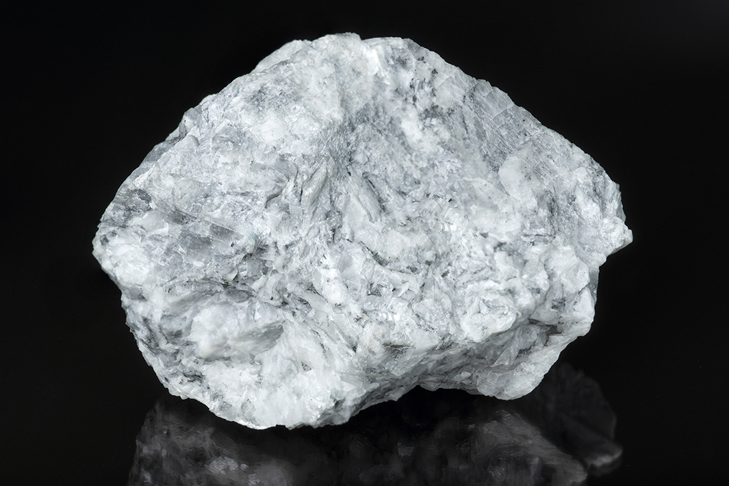 Gray-blue sodalite rock with white veins on a black background.