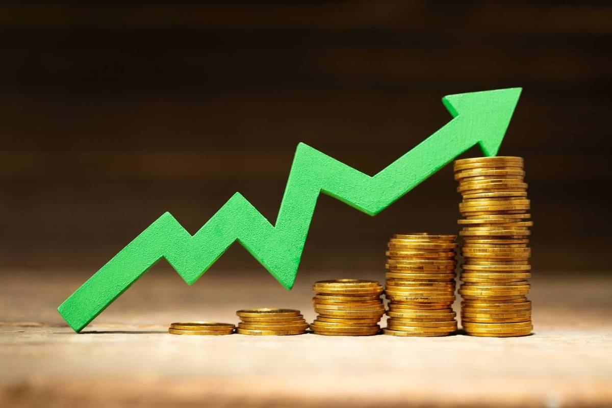 Green arrow rising over stacked gold coins, symbolizing financial growth.
