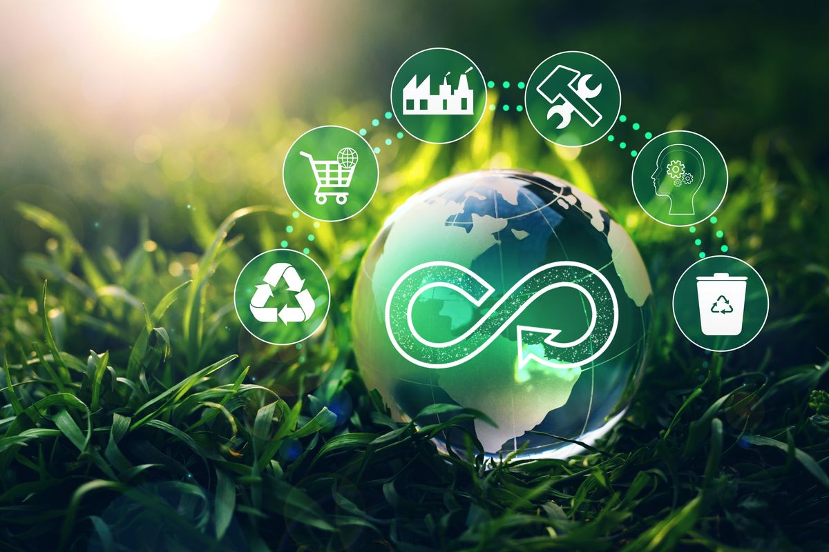green globe in grass with recycling symbols