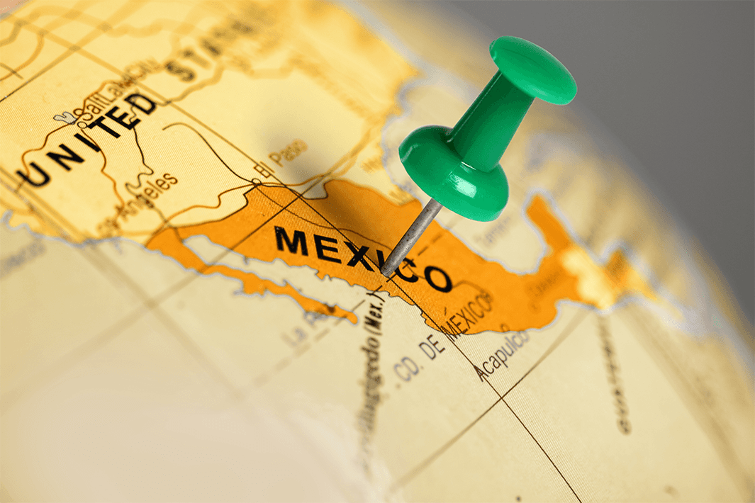 Green pushpin placed over Mexico.