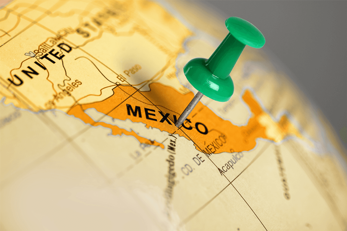 Green pushpin placed over Mexico.