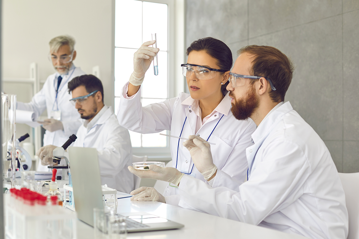 Group of male and female scientists working in laboratory.