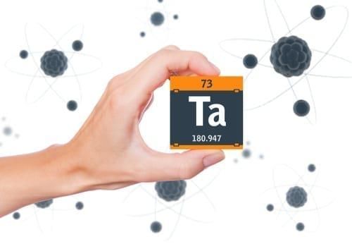 hand holding a square that shows tantalum's period table of elements information