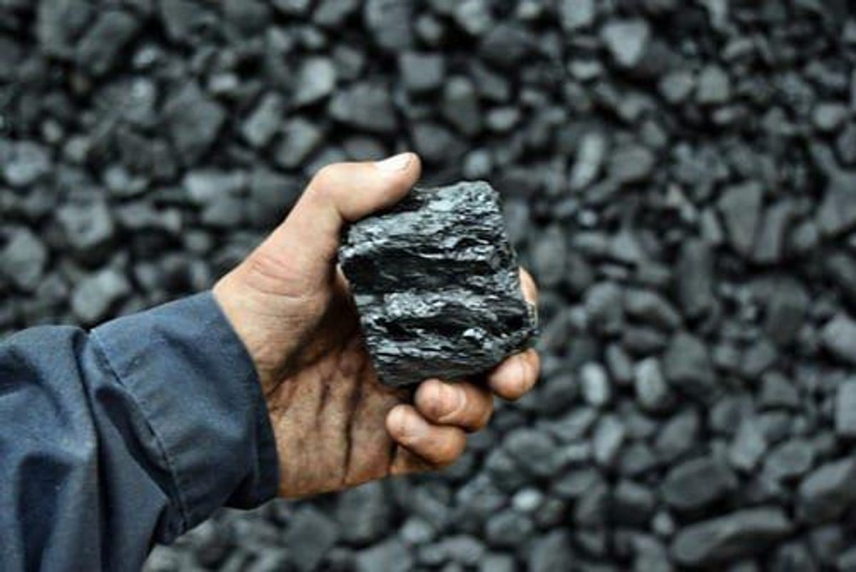 hand holding chunk of coal