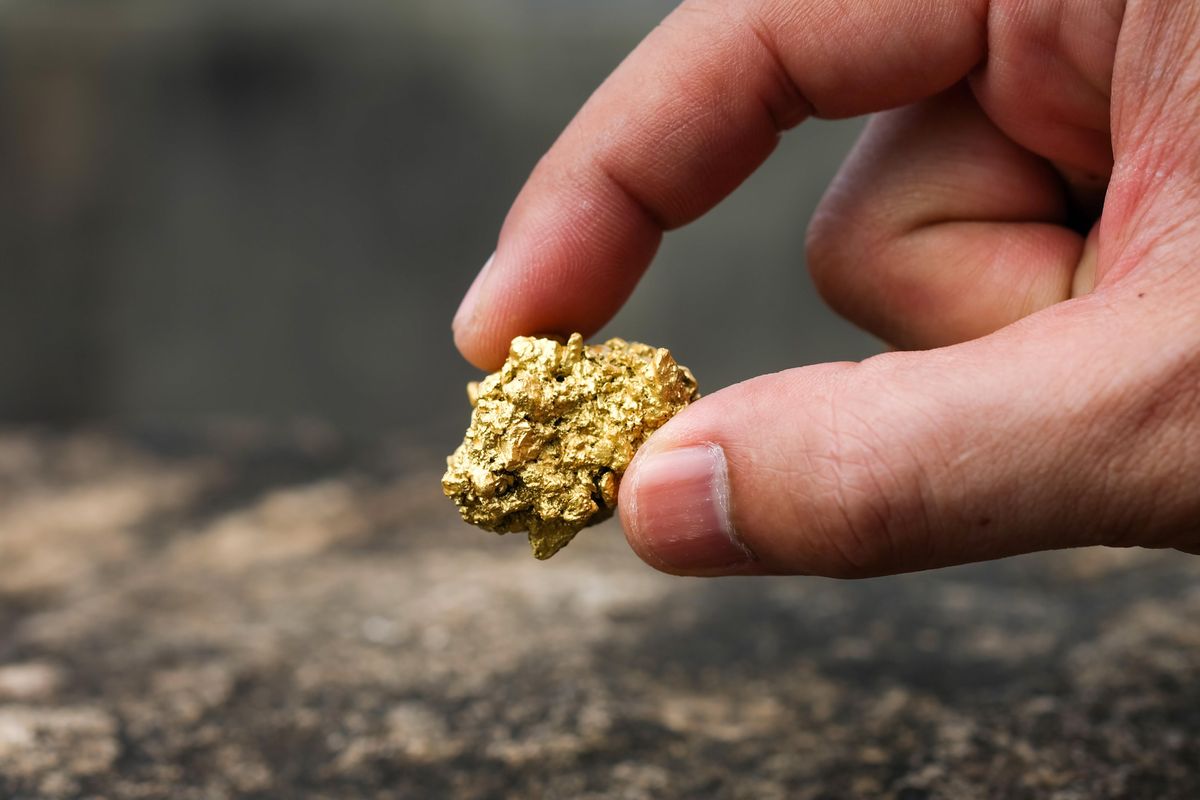 Hand holding gold nugget.