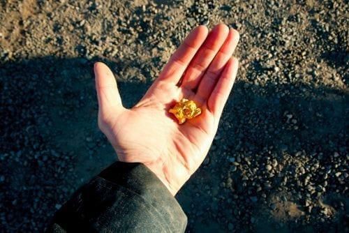 hand holding gold nuggets