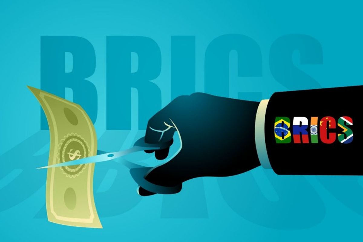 Hand labeled "BRICS" cutting paper money with scissors.