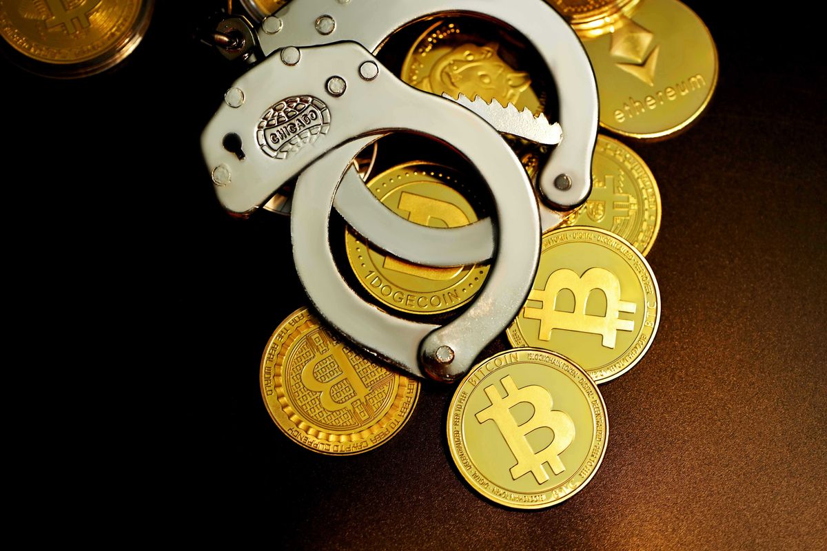 Handcuffs on cryptocurrency coins: Bitcoin, Ethereum, Dogecoin.