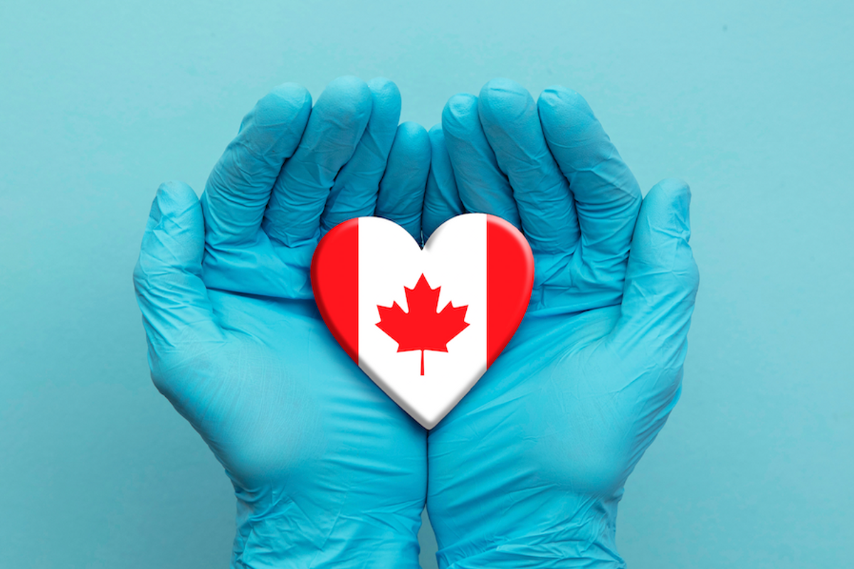 hands holding canadian flag heart
