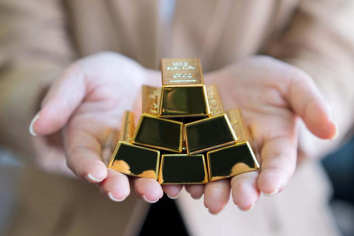 hands holding gold bars