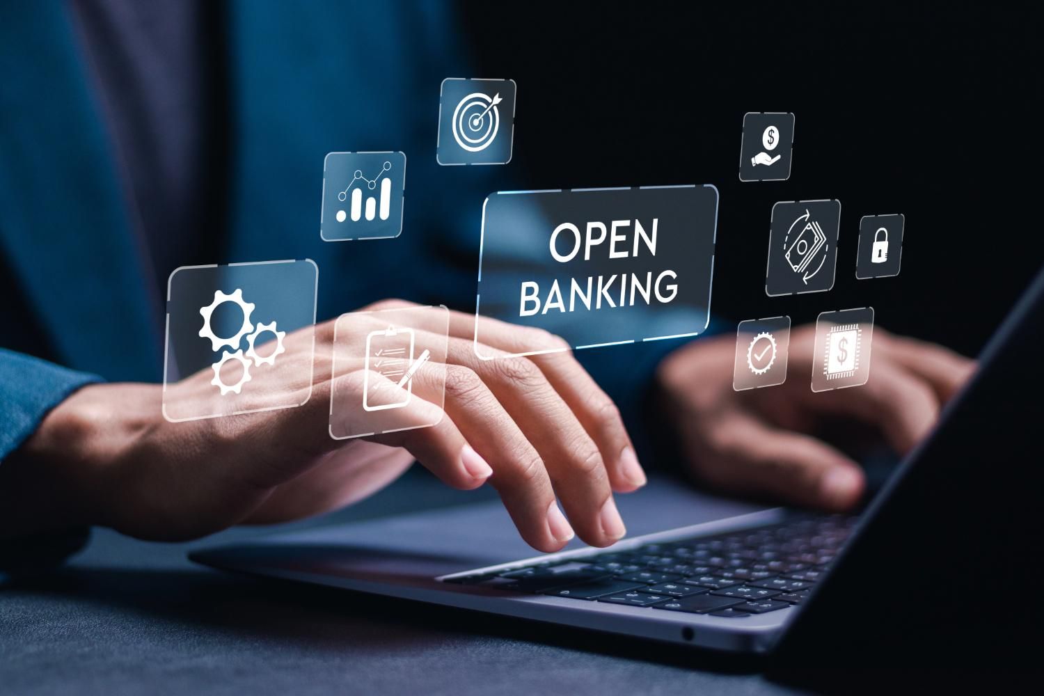 Hands typing on a laptop with "open banking" text and related icons hovering above.