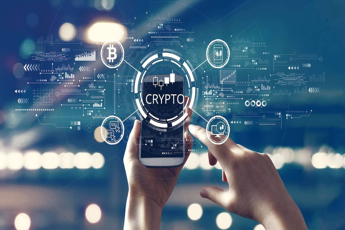 Hands using a smartphone with "crypto" and digital currency icons on the screen.