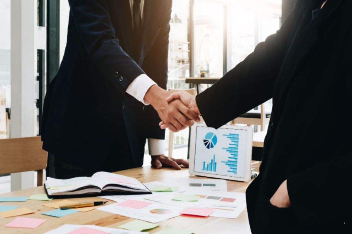 handshake across boardroom table