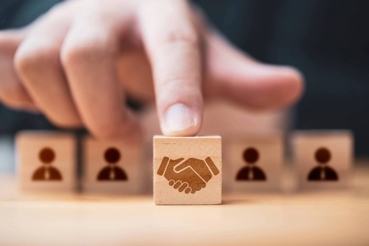 Handshake image on block representing M&A activity.