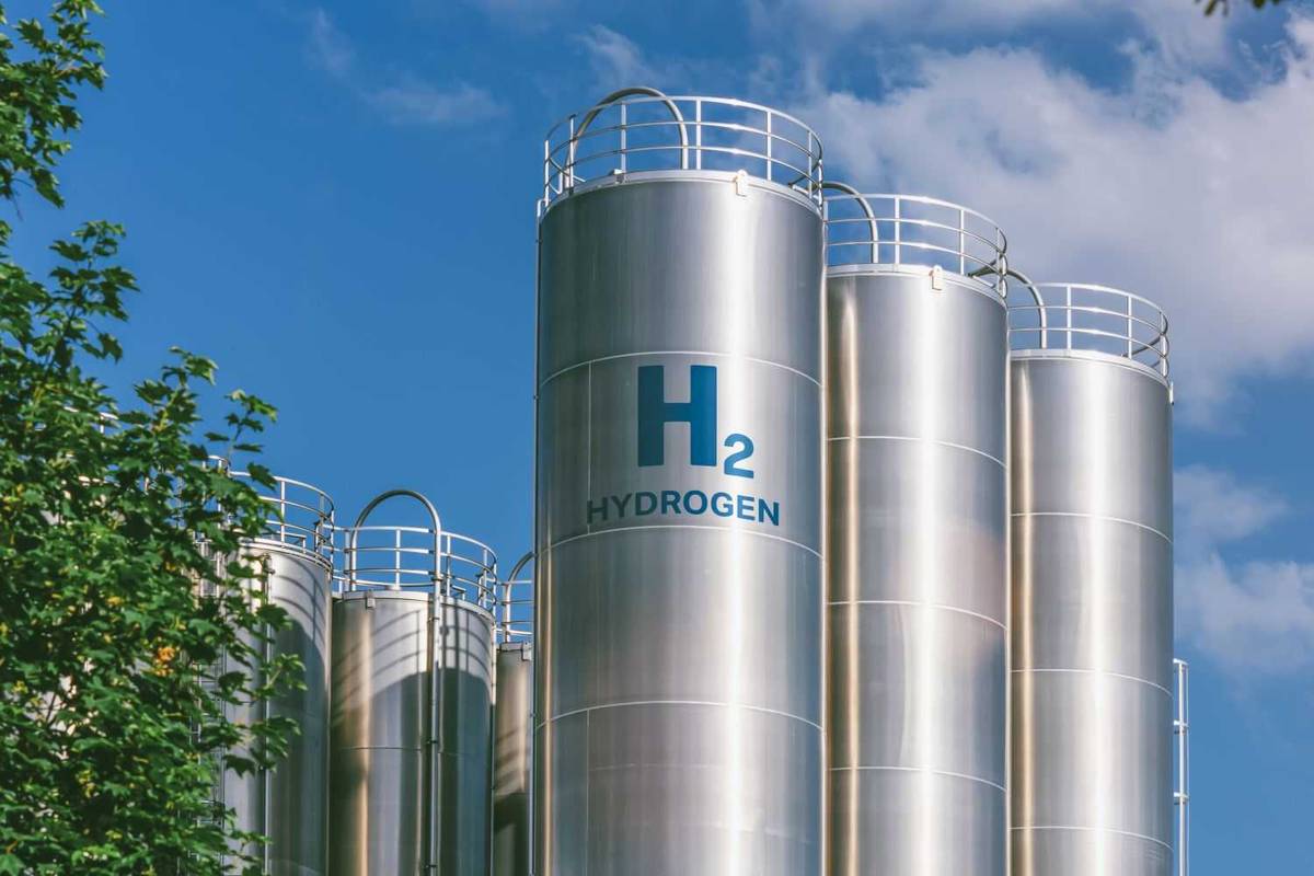 Hydrogen storage tanks under a blue sky with clouds.