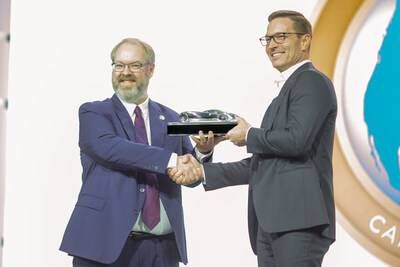Dodge CEO Matt McAlear (right) accepts the 2026 North American Car of the Year™ (NACTOY) award for the all-new Dodge Charger multi-energy lineup from NACTOY juror John Vincent at the 2026 Detroit Auto Show.