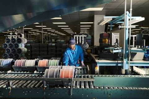 Employee processing fiber at a Corning optical fiber manufacturing facility.