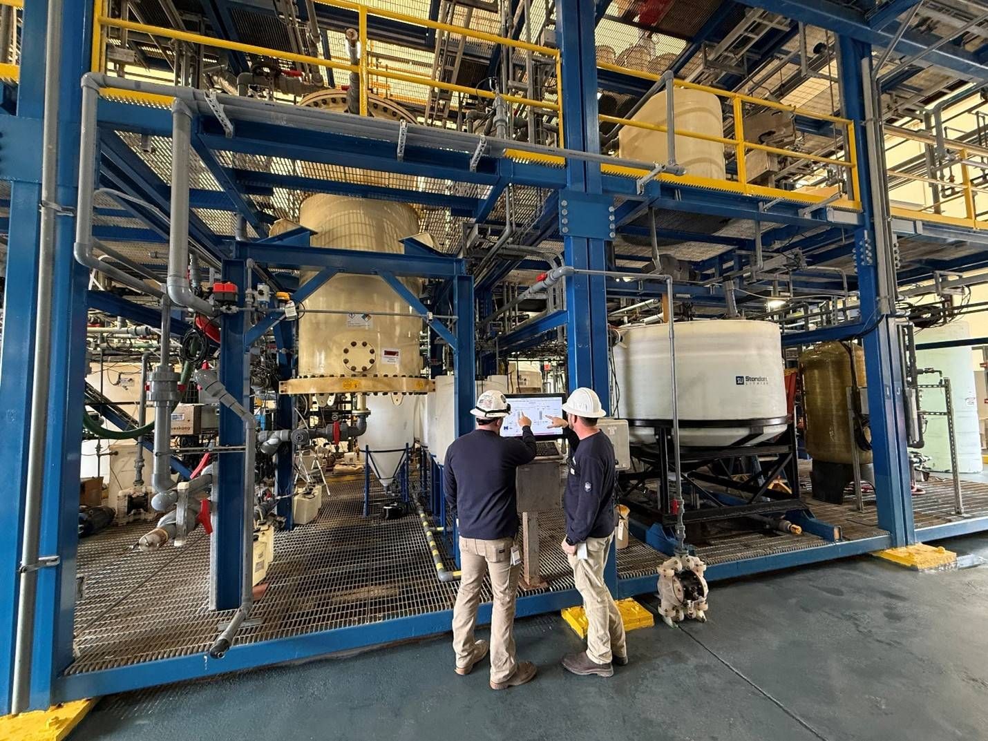 Operators at control panel in front of commercial-scale (8' x 4') DLE column at Standard Lithium's Demonstration Plant near El Dorado, Arkansas.