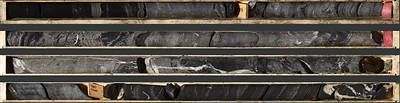 Photo 2: An interval of laminated to semi-massive sulphide mineralization in TS26-005 consisting of laminated to semi-massive sphalerite, galena, barite and black mudstone from 176.3 to 180.8 m