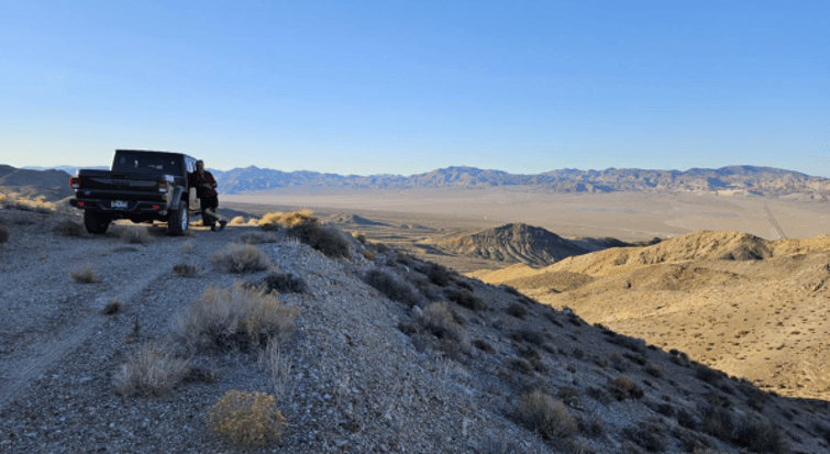 October 6, 2026: view north from near planned drill site J5 on the New Boston project in Nevada, a 300 m step-out from NB26-003 located to the west of this photo, behind the truck and down the Jeep Mine ridgeline, with the 2,892 ft intersection of continuous, polyphase stockwork veining with moly, copper, tungsten and silver mineralization. Note HWY 95 infrastructure in the background in the Soda Springs valley, a tremendous advantage for cost-effective exploration at New Boston.