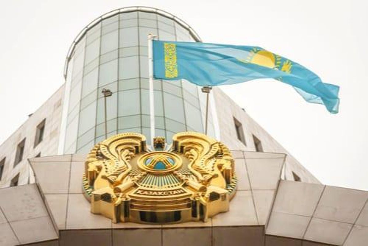 Kazakhstan emblem and flag on a modern building's facade.