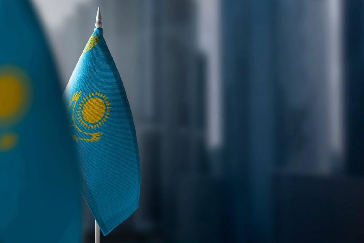 Kazakhstan flags with blue background, sun, eagle and vertical pattern on left.