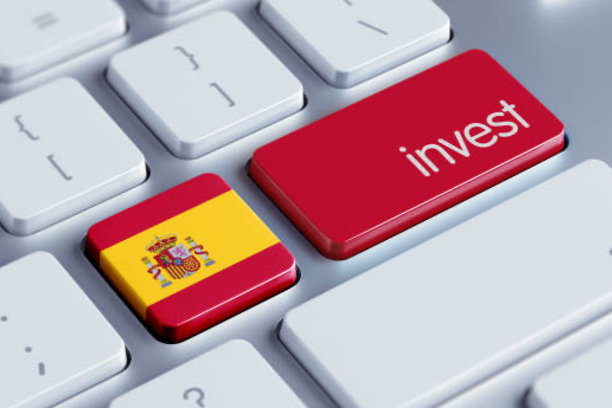 Keyboard with "invest" and Spain flag buttons.