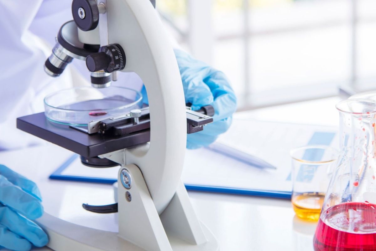 Lab worker using microscope.