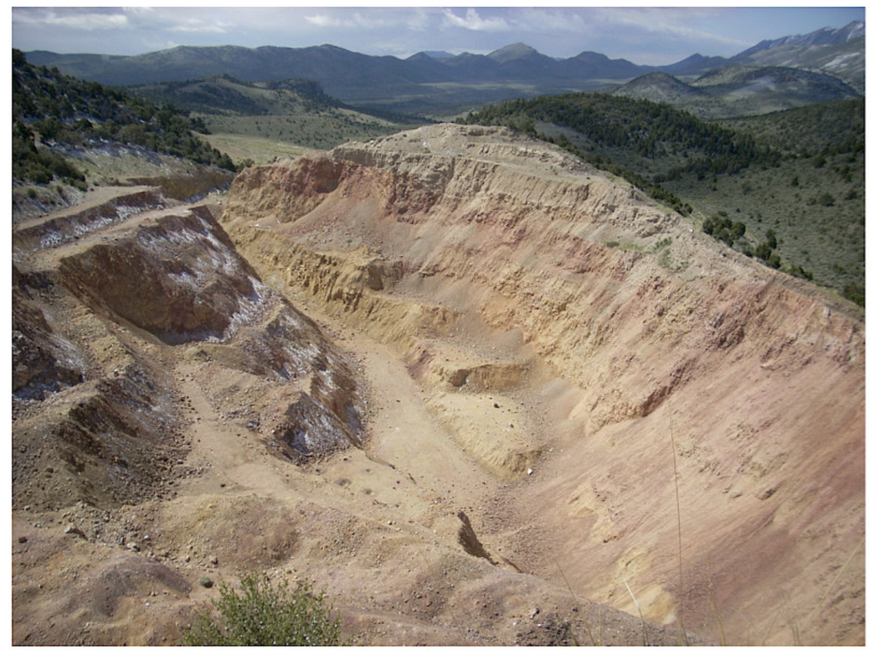 Large, open-pit mine in desert landscape with distant mountain at Nevada Sunrise Metals' Griffon Gold Mine