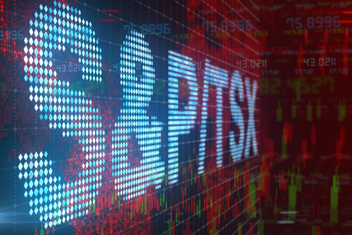 Large, white digital letters reading "S&P/TSX" in front of red and green stock charts.