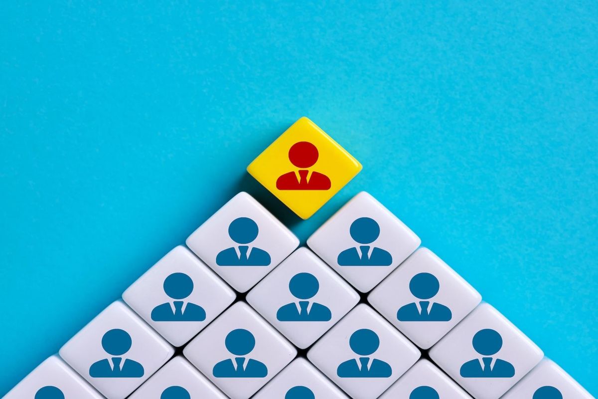 Leader icon on yellow block atop blue icons on white blocks, forming a pyramid.