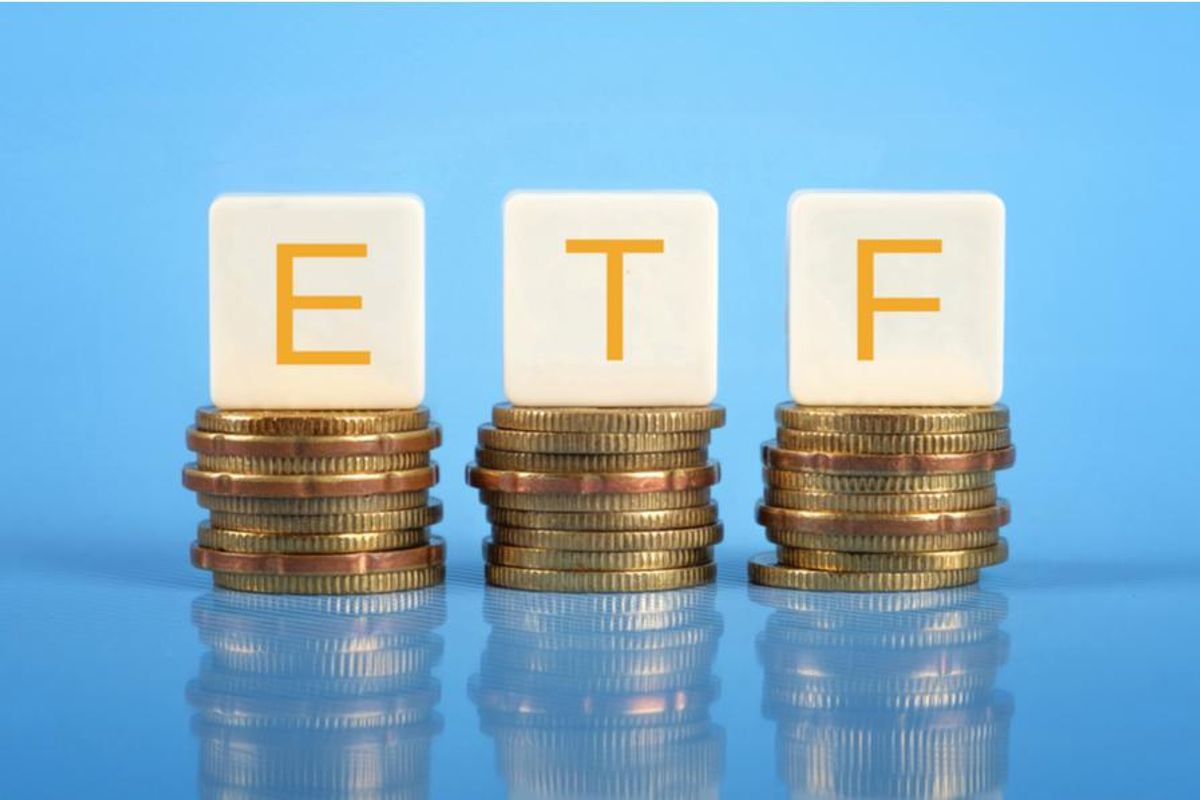 letter blocks spelling "etf" sit on top of piles of coins