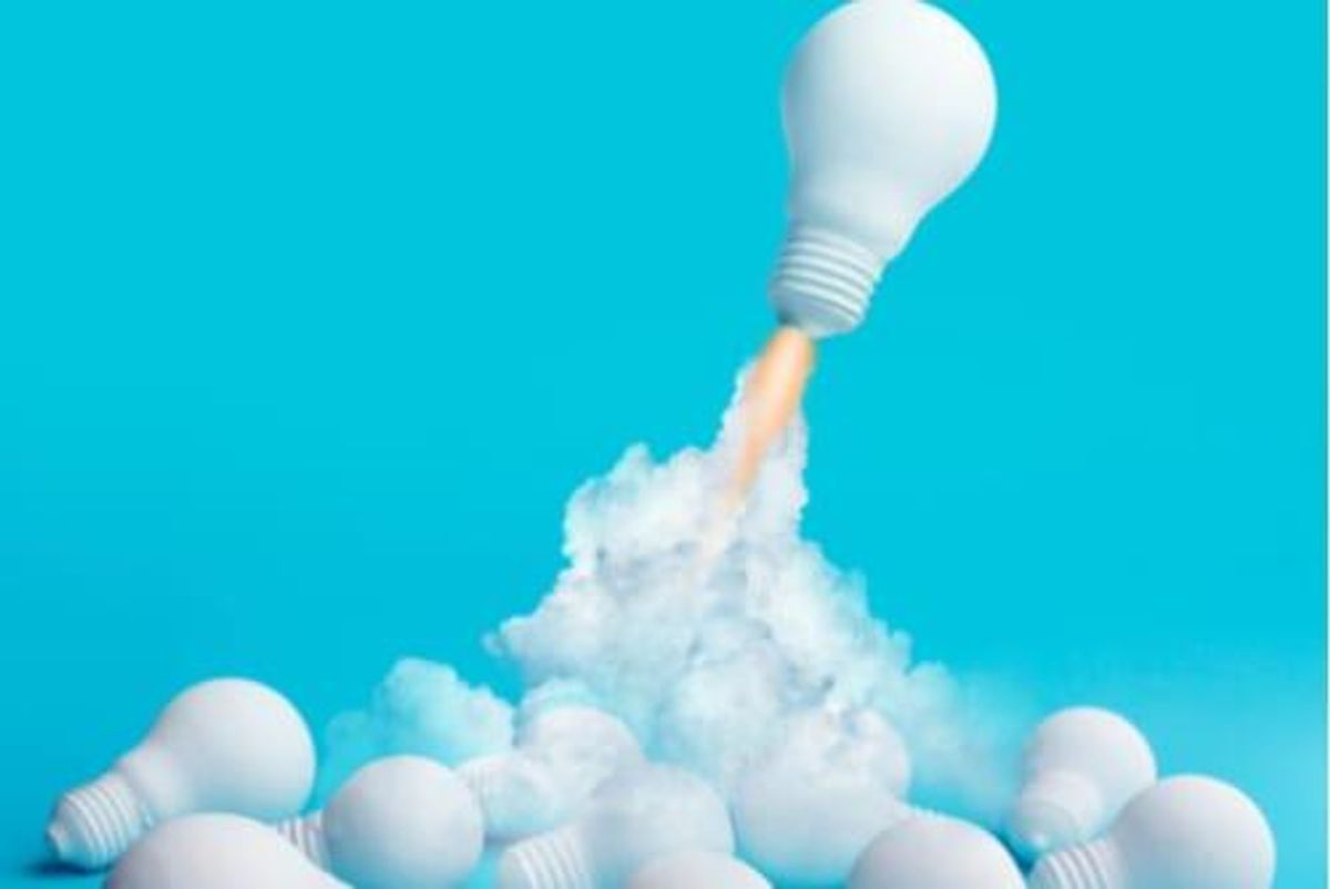 light bulb rocketing away from pile of light bulbs