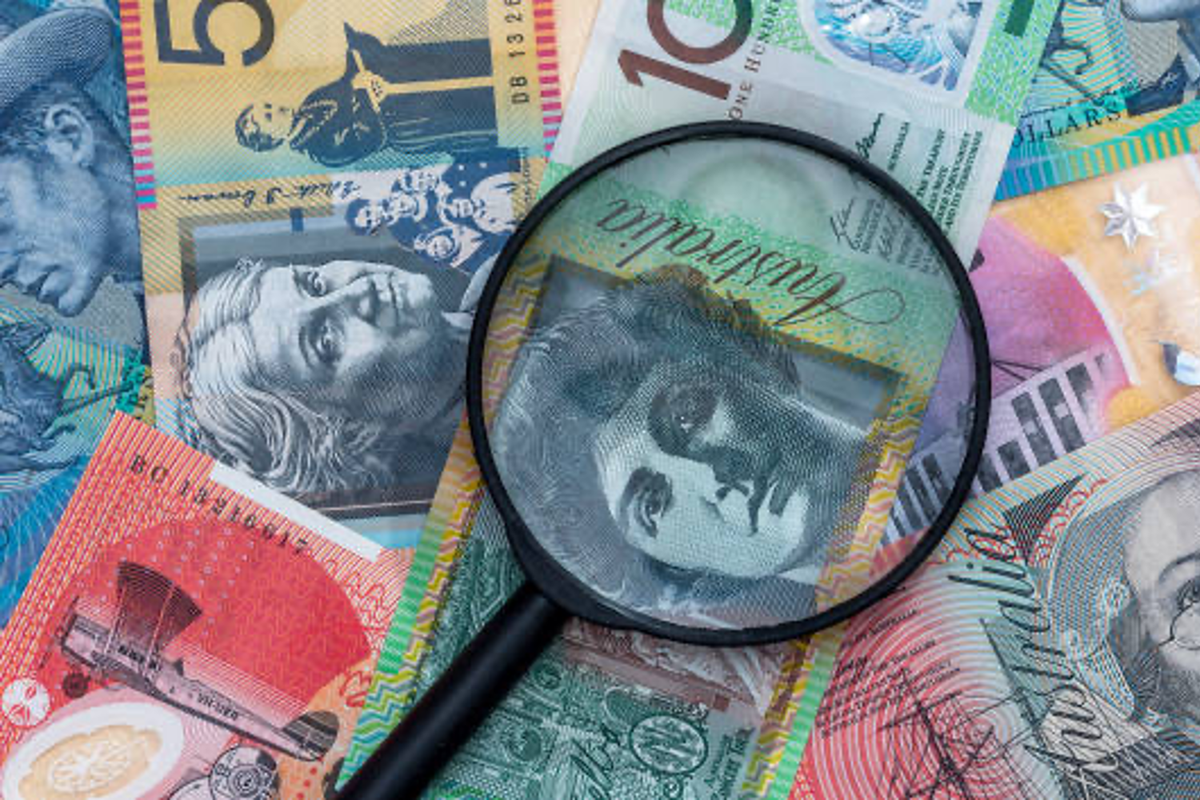 Magnifying glass on a bed of Australian money.