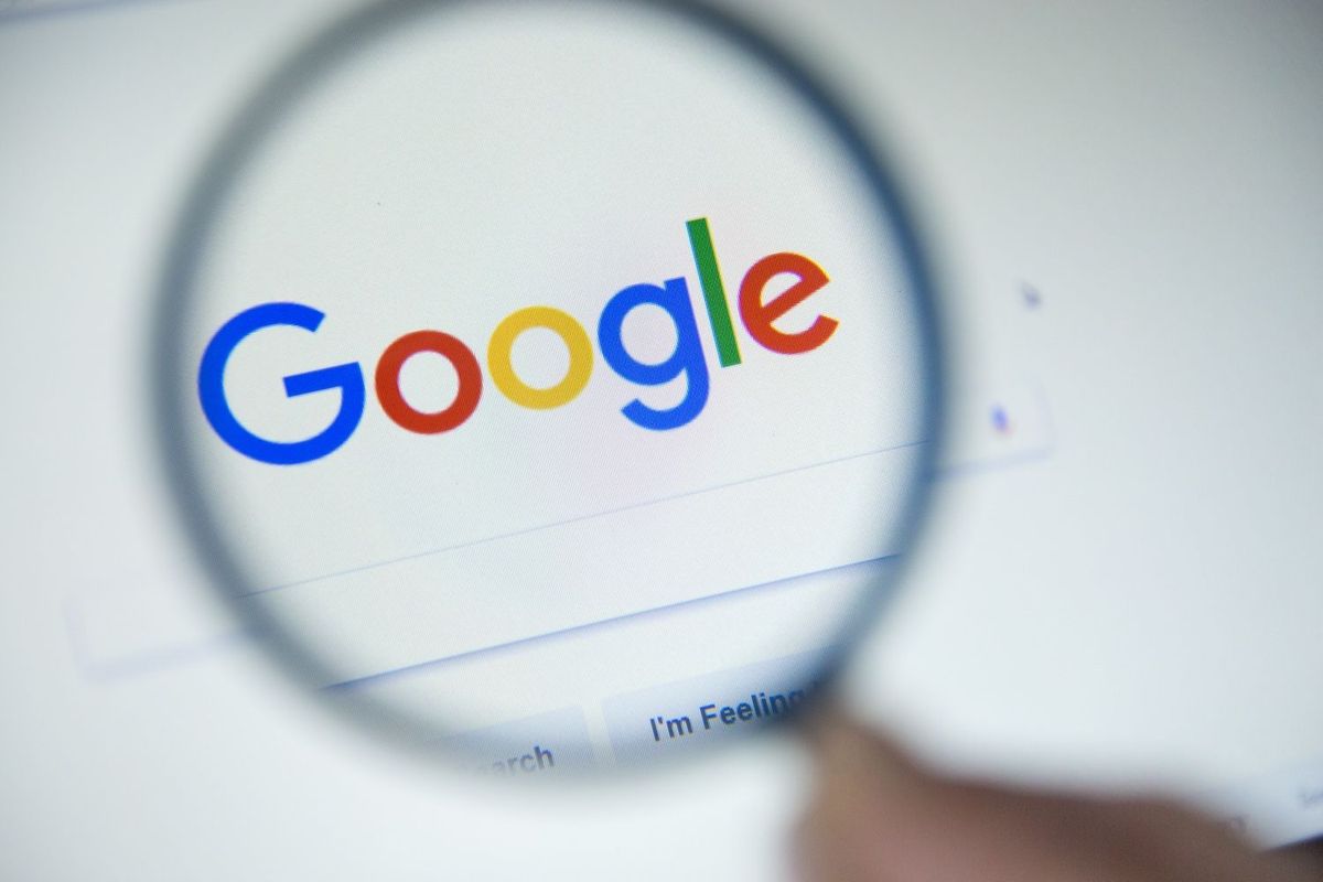 Magnifying glass over Google's search page, focusing on the colorful logo.
