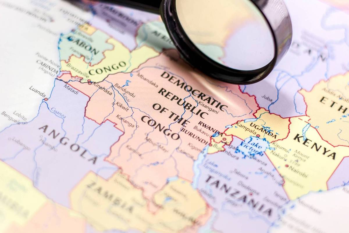 Magnifying glass rests over a map highlighting the Democratic Republic of Congo in Central Africa.