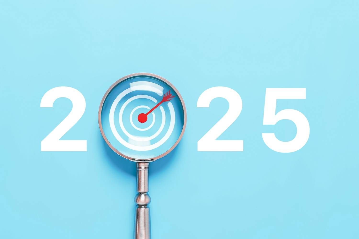 Magnifying glass targets zero in 2025 on blue background.