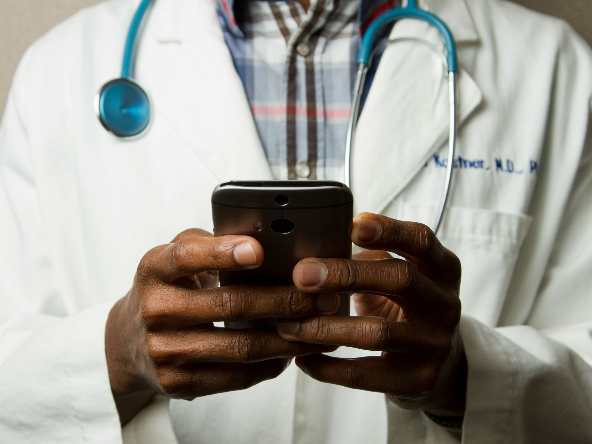 male doctor holding cell phone