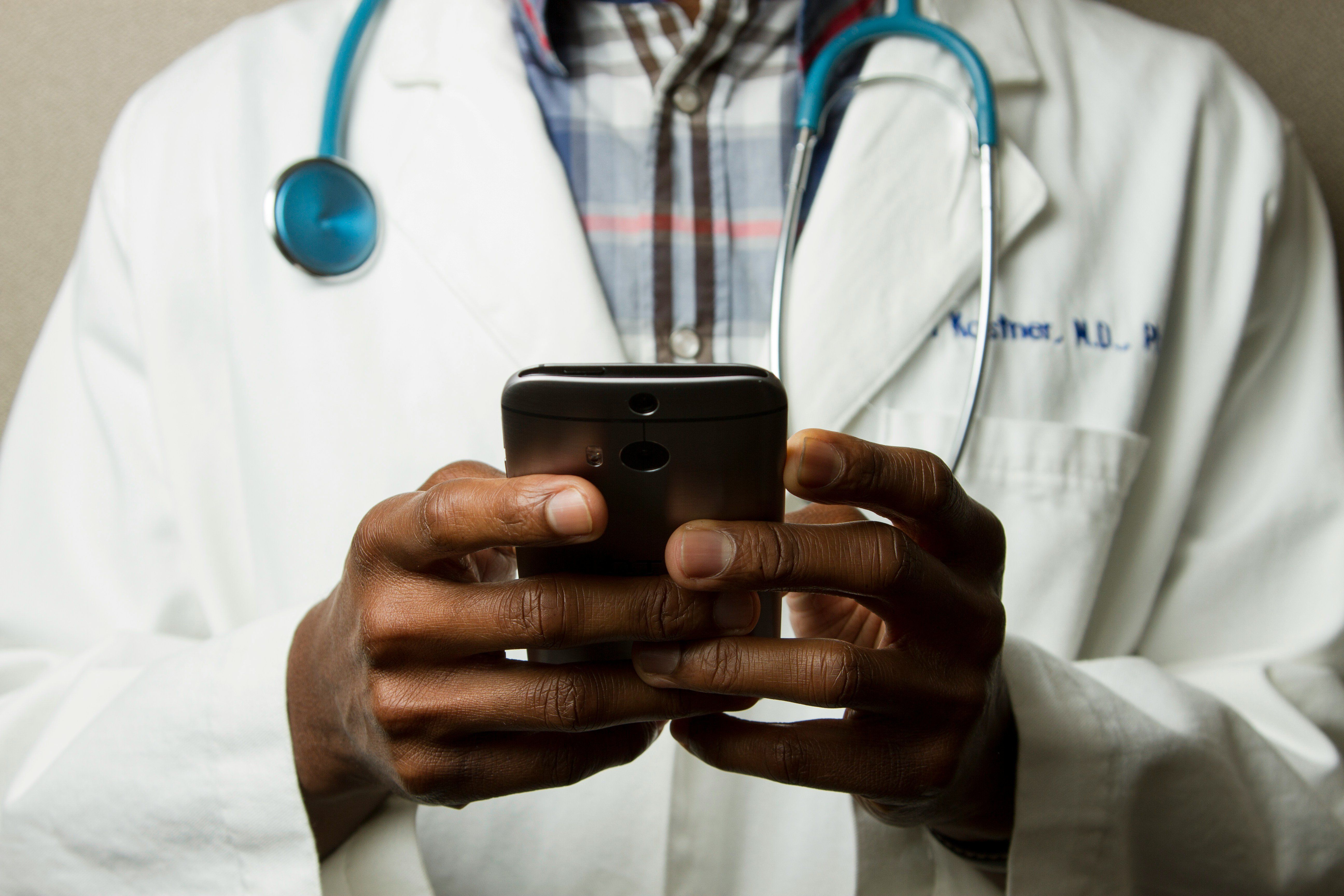 male doctor holding cell phone