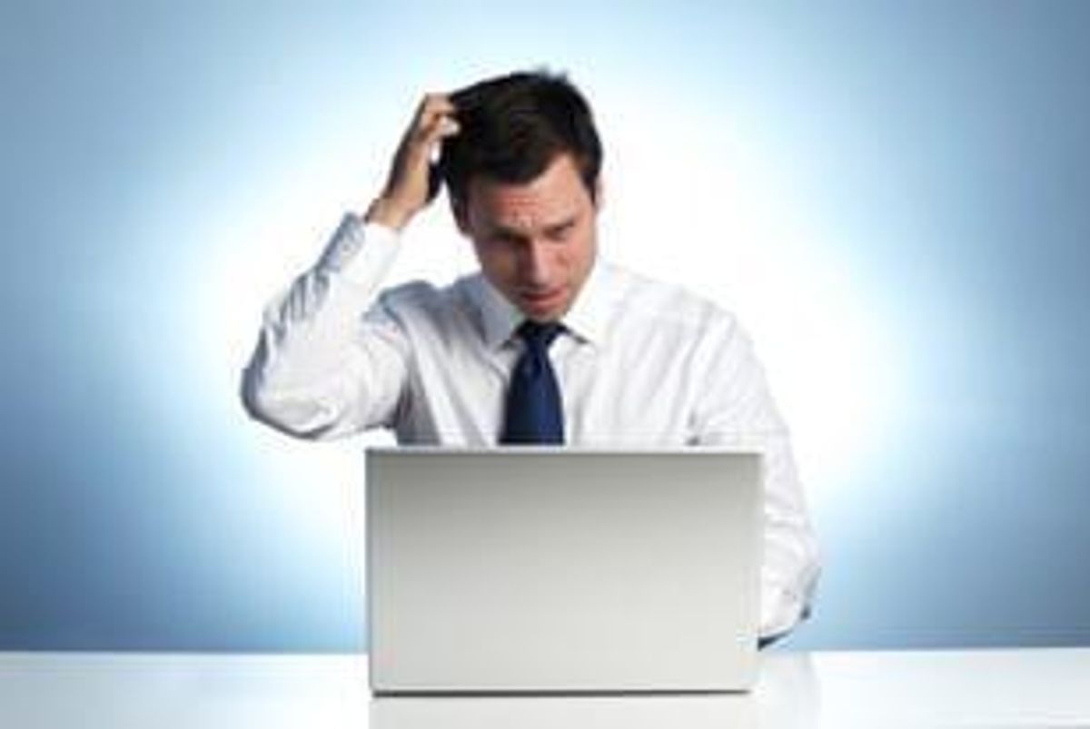 man at laptop scratching his head
