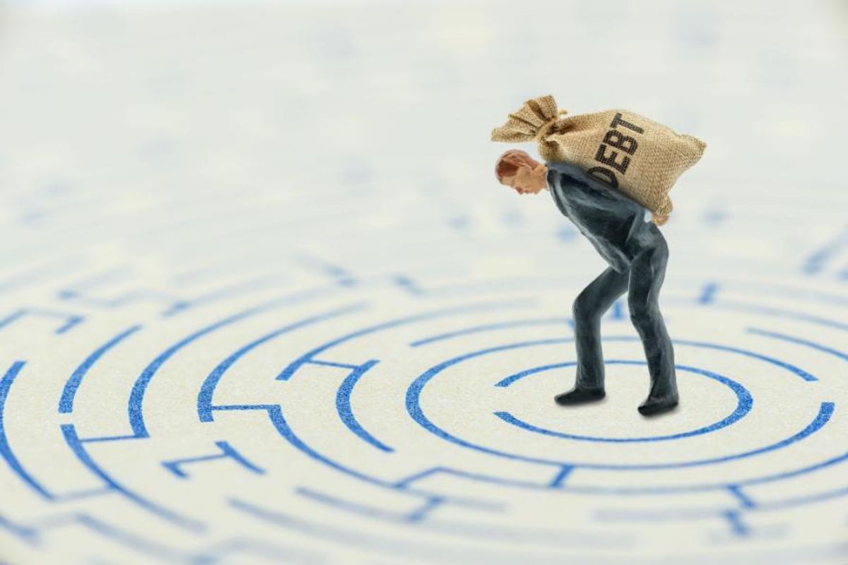 man carrying bag that says "debt"