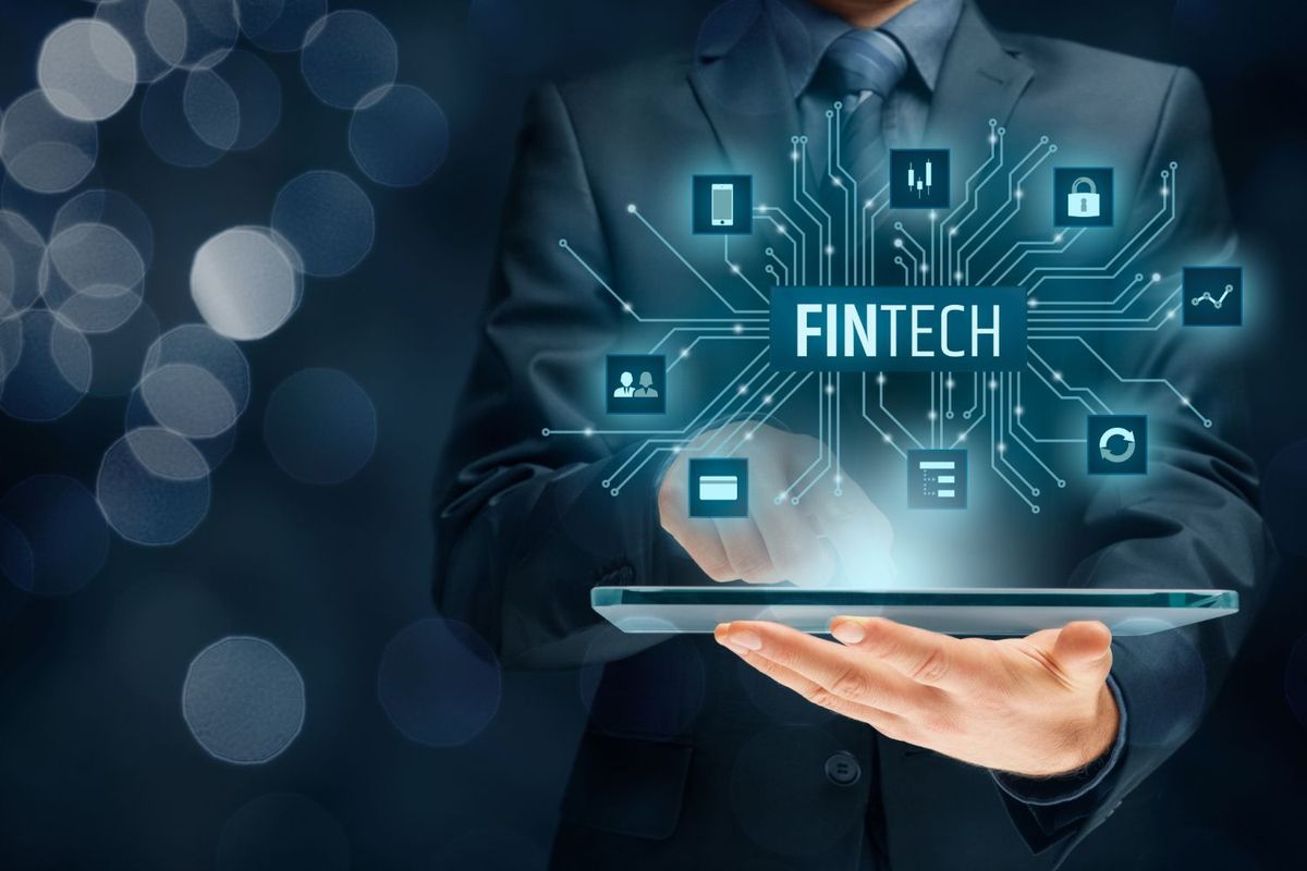 Man holding iPad with fintech imagery above.