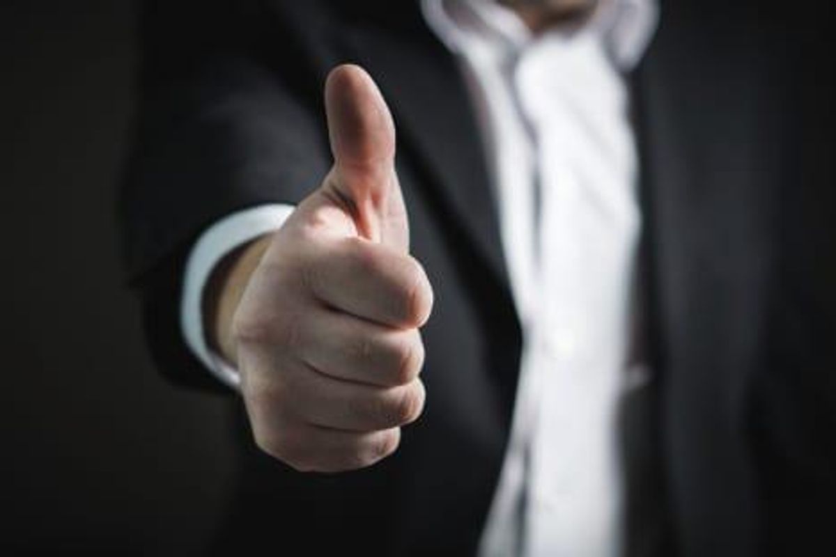 man in suit giving thumbs up