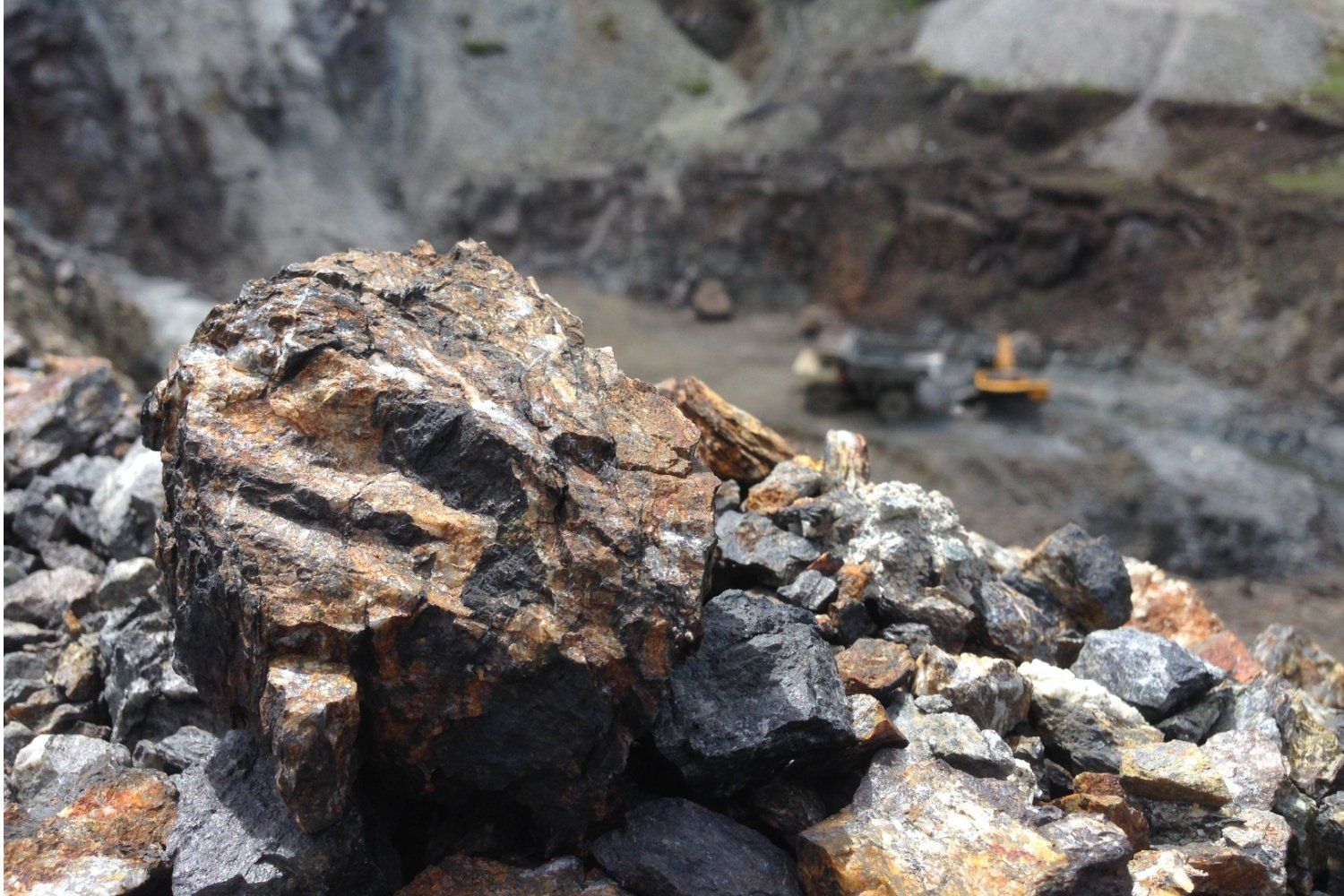 Manganese ore in the foreground at an open-pit manganese mine.