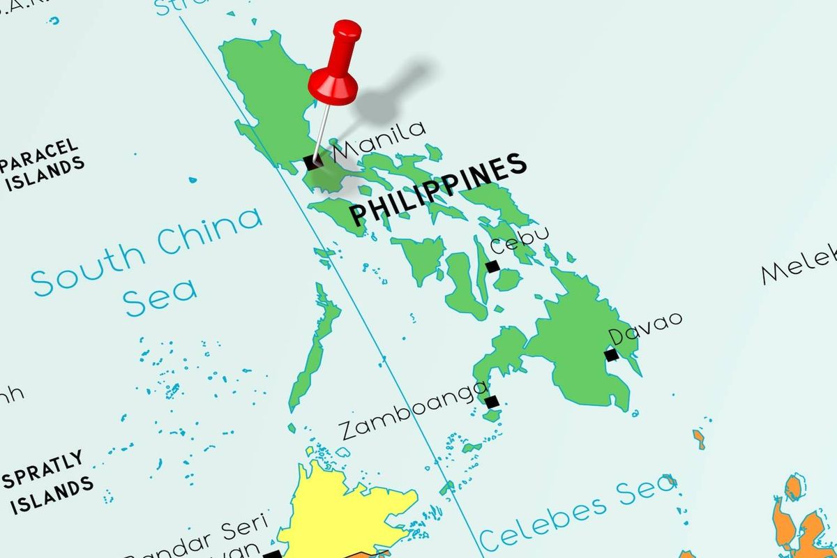 Map of the Philippines with a red pushpin over Manila, text reads: South China Sea, Celebes Sea.