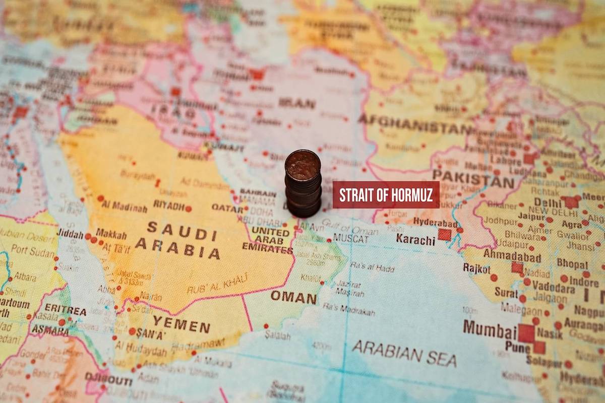 Map showing the Middle East with a coin stack over the Strait of Hormuz; text reads: Strait of Hormuz.