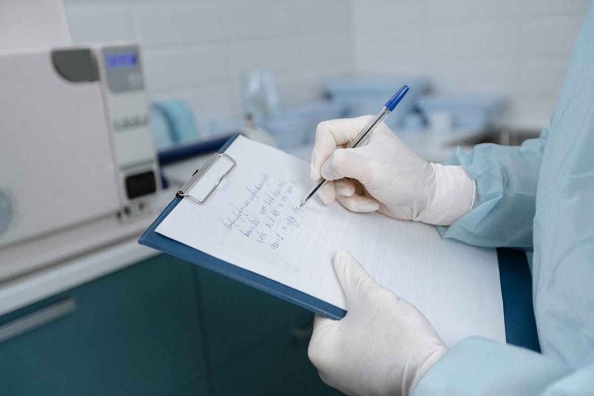 medical worker writing on clipboard